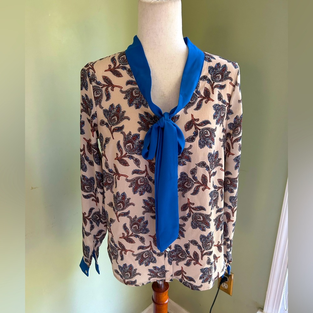 Hayden Los Angeles blouse w/blue tie neck detail. Cream w/deep color print.Small